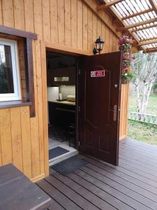 une cabine en bois avec une porte ouverte sur une terrasse dans l'établissement Zacisze u Ani, à Siemiany
