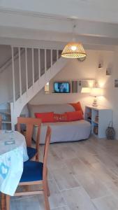 ein Wohnzimmer mit einem Bett und einem Tisch sowie ein Zimmer in der Unterkunft Location d'un pavillon de vacances in Marseillan