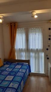 a bedroom with a bed and a window with curtains at Location d'un pavillon de vacances in Marseillan +5 photos