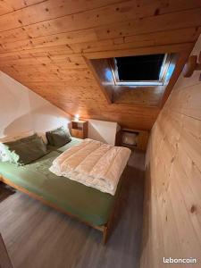 een groot bed in een kamer met een houten plafond bij Duplex la Plagne Montalbert in Aime La Plagne