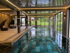 a swimming pool in a house with a large glass door at Oasis Resort & Spa in Rewal