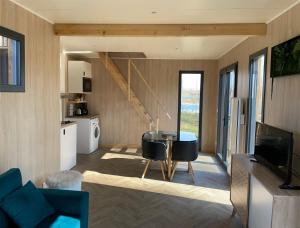 a living room with a table and a kitchen at Au fil de l’eau, gîte nature in Abbécourt