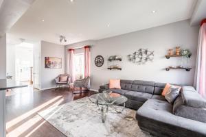 a living room with a couch and a glass table at Luxury 3BR 2BA Townhome with Private HOT TUB, Gym, BBQ by GLOBALSTAY in Hamilton