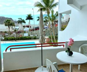 uma varanda com uma mesa e uma piscina em Apartamento El Cardenal em Playa del Cura