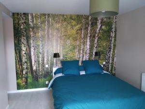 a bedroom with a wall mural of aspen trees at Les Chambres d Odile in Lachapelle-sous-Chaux