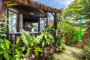 a garden cabin with a bench and plants at Bali Brothers Guesthouse in Dalung