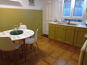 a kitchen with a table and chairs and a sink at Can Eugeni in L'Escala