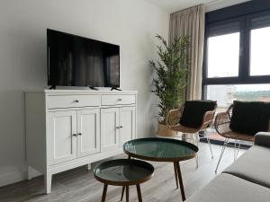 uma sala de estar com uma televisão num armário branco em Rotonda del Minotauro Apartamento Turístico em Coria