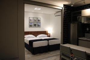 a small bedroom with a bed and a kitchen at Flats Monsenhor31 - Localizado no centro da cidade in Paulo Afonso