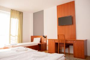 Televízia a/alebo spoločenská miestnosť v ubytovaní Triple M Hotel