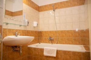 a bathroom with a sink and a bath tub at Triple M Hotel in Budapest