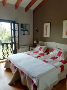 a bedroom with two beds and a balcony at El Oteru II in Gancedo