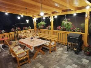 a patio with a table and chairs and a grill at Ágica Vendégház in Andornaktálya