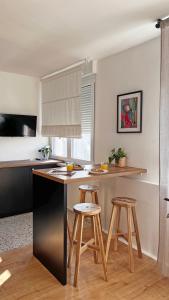 a kitchen with a counter and stools in a room at Studio apartman Siget II in Zagreb