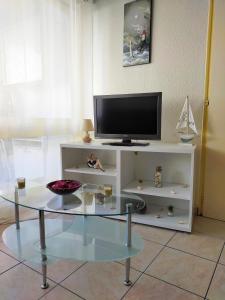 a living room with a tv and a glass table at Appart Bord de Mer, 6 PLaces, Plage à 250 m, Dune, Parking gratuit, Rez de Chaussée surélevé in Saint-Hilaire-de-Riez