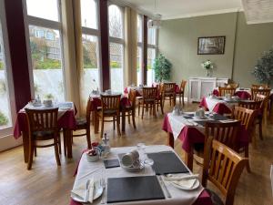 a dining room with tables and chairs and windows at The Belmont in Shanklin