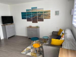 a living room with a couch and two stools at ESCAPADE FAMILIALE A LA MER in Quiberon