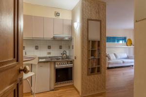 HospitalityRome Navona Studio Apartment في روما: مطبخ مع باب مفتوح يؤدي إلى غرفة معيشة