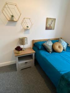 奧本的住宿－Newly refurbished town centre apartment，一间卧室配有蓝色的床和床头柜