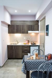 a kitchen with a table and chairs and a kitchen with a sink at Studio Elena in Nea Peramos