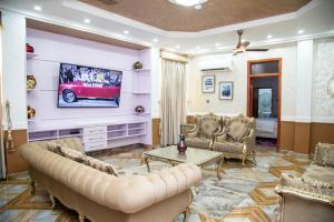 a living room with a couch and a tv at Macoba Luxury Apartments in Kumasi