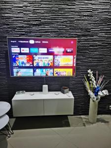 a room with a white table and a tv on a wall at Garden z ogródkiem na Waszyngtona in Białystok