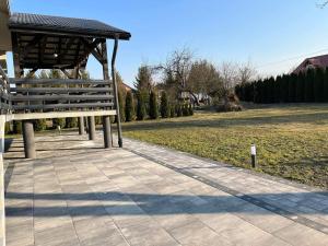 una panchina seduta accanto a un parco con un campo di Villa Sanriver a Przemyśl