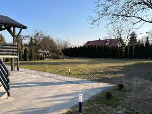 un parque con un banco y un campo con una casa en Villa Sanriver en Przemyśl