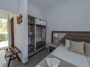 a bedroom with a large white bed and a chair at Ena-Lia Studios in Skala Marion