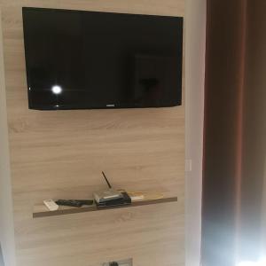 einen Flachbild-TV an der Wand mit Fernbedienung in der Unterkunft Ellen Apartamentos in Espargos