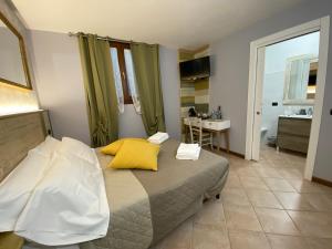1 dormitorio con 1 cama con almohadas amarillas y baño en Bed & Breakfast Ca'Bassano en Bassano del Grappa