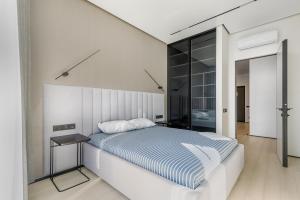 Habitación blanca con cama y espejo en Luxury Waterfront 3-bedrooms Apartment, en Odessa