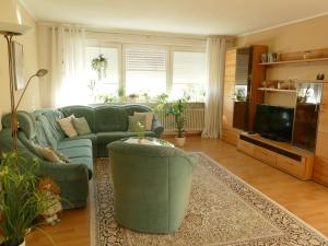 a living room with a couch and a tv at Ferienwohnung Kirsch in Sankt Wendel