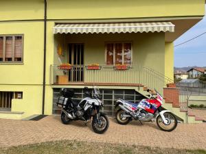 dos motocicletas estacionadas frente a una casa en Sole, en Gattinara