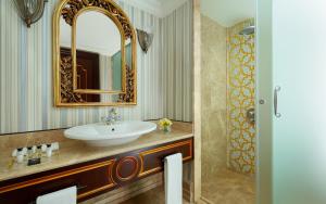 a bathroom with a sink and a mirror at Rixos Almaty Hotel in Almaty