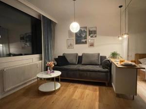 a living room with a couch and a table at Seeblickplatzl 220 - mit Seeblick zum Wolfgangsee in Strobl