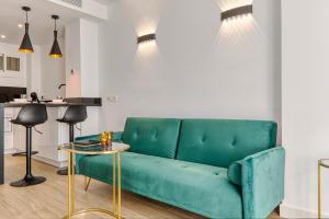 een woonkamer met een groene bank en een tafel bij Estudio DELUXE A ESTRENAR in Benalmádena