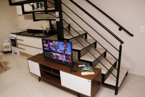 a living room with a television on a table next to a staircase at POUSADA GERMÂNICA in Marcelino Ramos