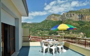 a patio with a table and a colorful umbrella at Residence Green Park in Ventimiglia