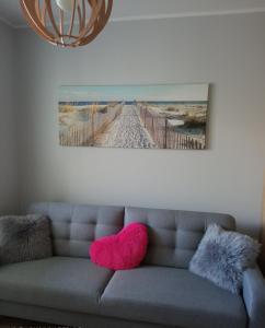 a living room with a couch with two pink pillows at Nadmorski Apartament Dream w Gdańsku in Gdańsk