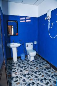 a blue bathroom with a toilet and a sink at City Elephant Family Resort in Udawalawe