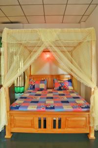 a bedroom with a bed with a canopy at City Elephant Family Resort in Udawalawe