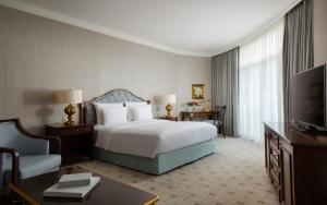 アルマトイにあるリクソス アルマトイ ホテルのベッドとテレビが備わるホテルルームです。