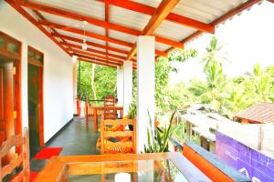 a balcony of a house with a table and chairs at City Elephant Family Resort in Udawalawe
