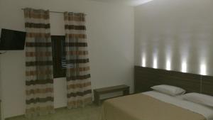 - une chambre avec un lit et une fenêtre avec un rideau dans l'établissement Pandora B&B, à Porto Cesareo