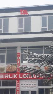 a sign in front of a building with a pizza at Çiftlik otel 