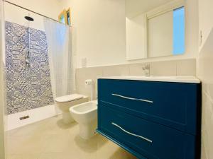 łazienka z niebieską szafką i toaletą w obiekcie L'Orto di Grace w Sorrento