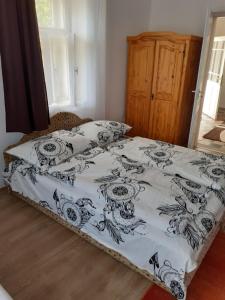 1 cama con edredón blanco y negro en Bella Apartman, en Sárospatak