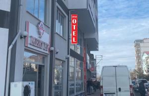 a building with a neon sign on the side of it at Çiftlik otel in Çiftlik