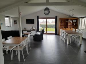 a living room with tables and chairs and a clock on the wall at de blinker in Knokke-Heist